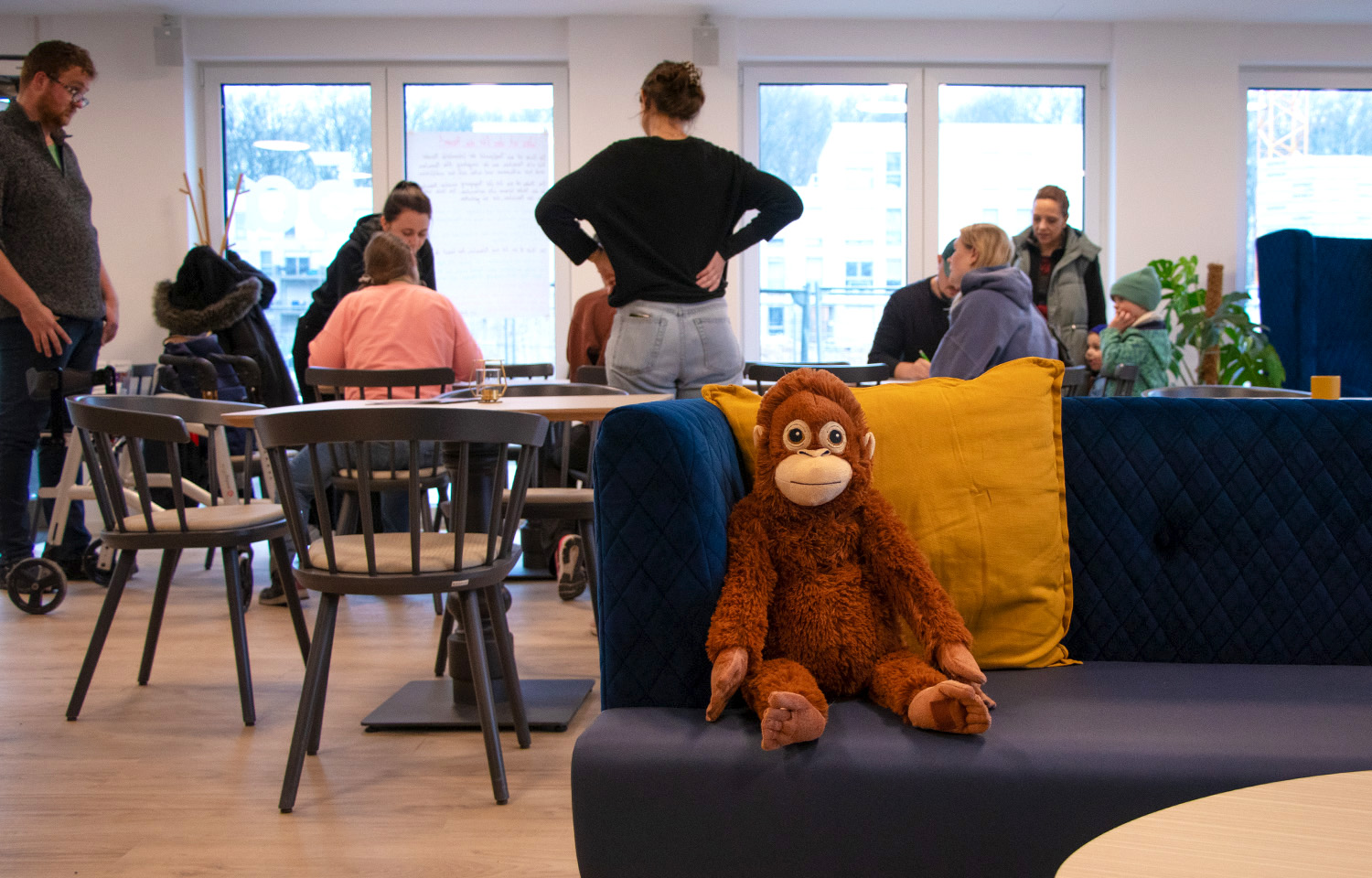 Kuscheltier in der Stube mit Menschen im Hintergrund