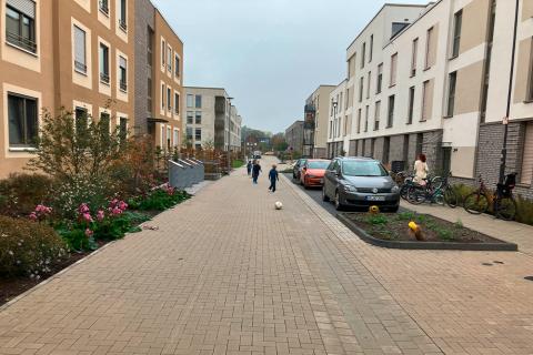 Kinder spielen auf Straße zwischen Häusern